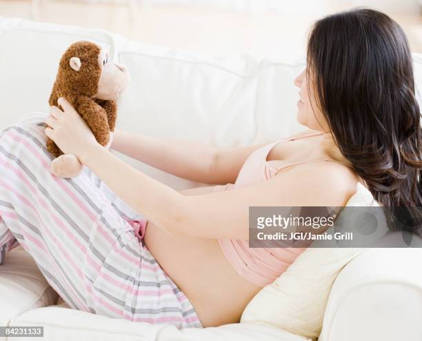 pregnant asian woman holding stuffed animal - animal abdomen stock-fotos und bilder