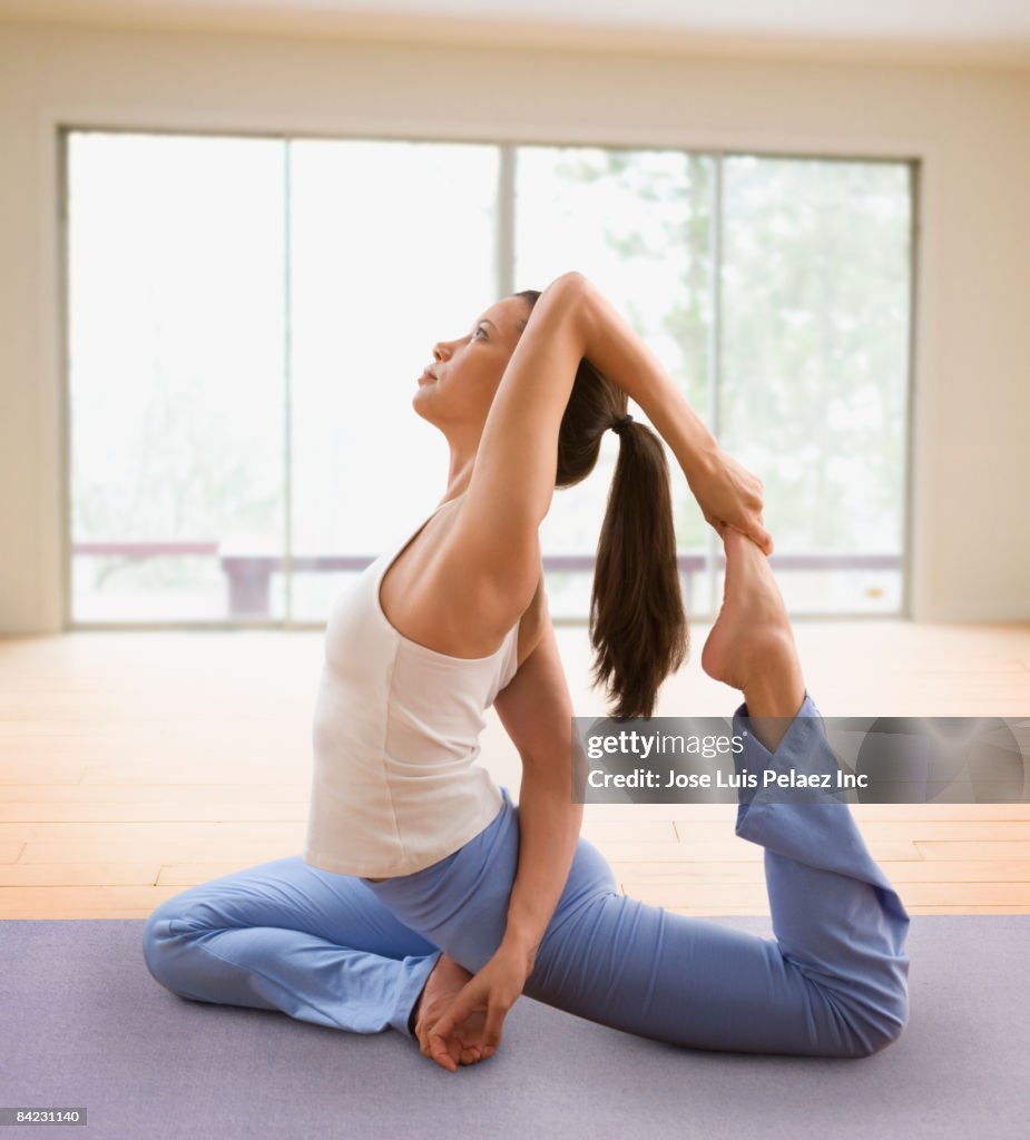 Mixed race woman doing yoga