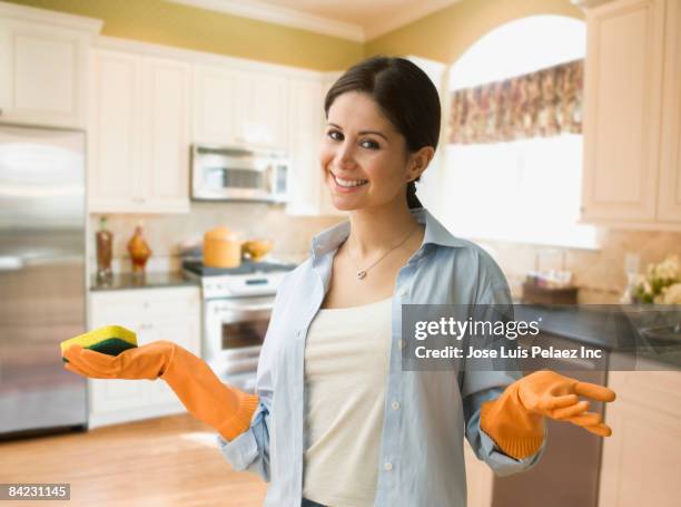 housewife in rubber gloves holding sponge in kitchen - frau putzen stock-fotos und bilder