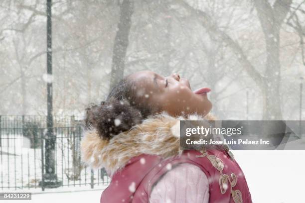 mixed race girl catching snowflakes on her tongue - catching snowflakes stock pictures, royalty-free photos & images