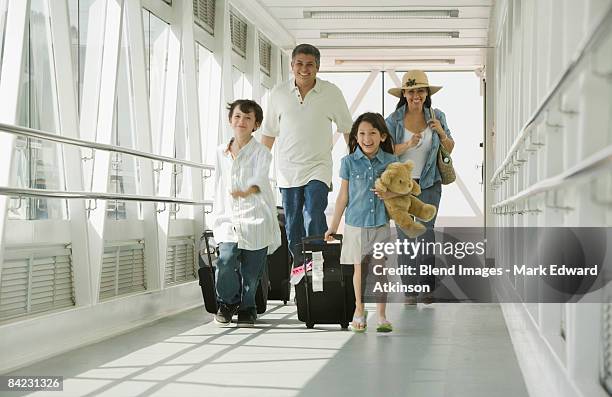 hispanic family walking through airport - leaving airport stock pictures, royalty-free photos & images