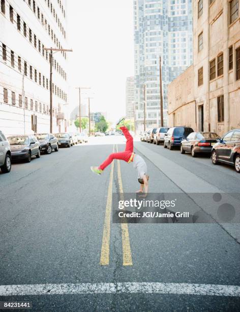 hispanic teenage boy doing back flip in urban street - boy handstand stock pictures, royalty-free photos & images