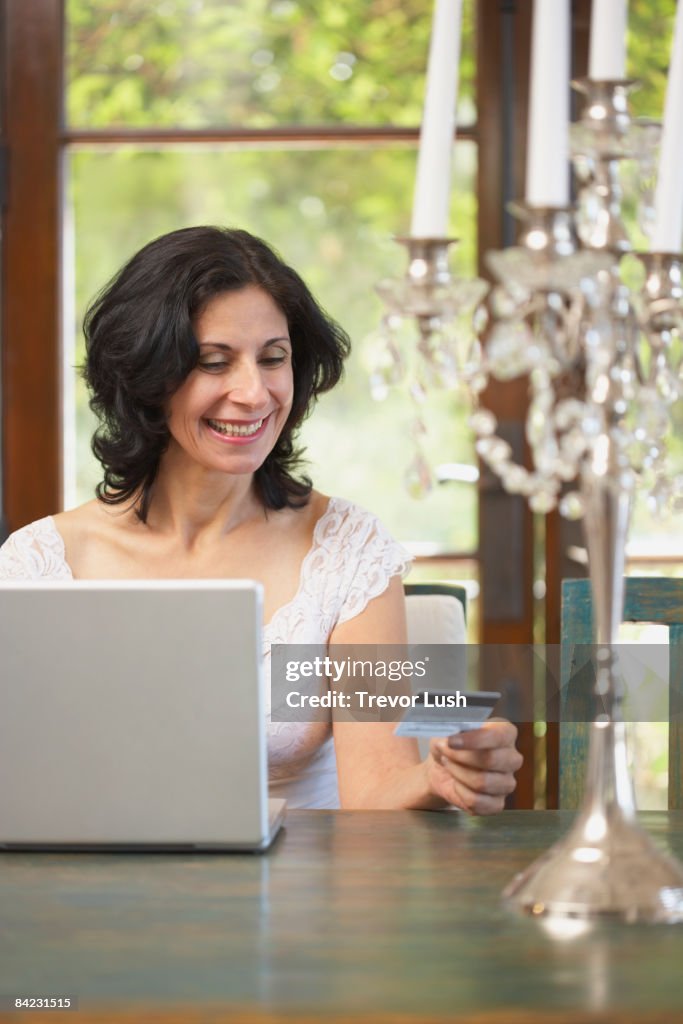 Confident Middle Eastern woman shopping online with credit card
