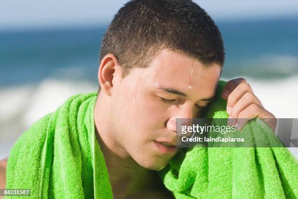sweating hispanic man wiping face with towel - heat exhaustion stock pictures, royalty-free photos & images