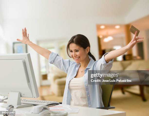 cheering woman shopping online with credit card - euforie stockfoto's en -beelden