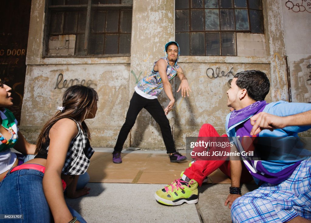 Alternative friends break dancing in urban setting