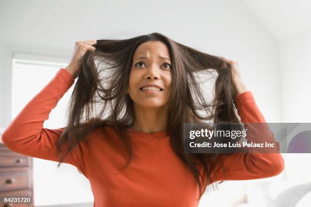 frustrated mixed race woman pulling her hair - pulling stock pictures, royalty-free photos & images