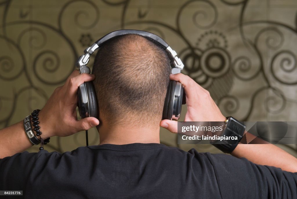 Hispanic man adjusting headphones