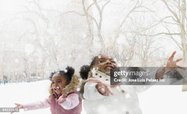 mixed race girls catching snowflakes - snow fun stock pictures, royalty-free photos & images