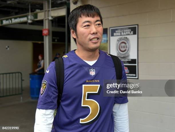 Koji Uehara of the Chicago Cubs wears a football jersey as the Cubs leave on their road trip September 3, 2017 at Wrigley Field in Chicago, Illinois.