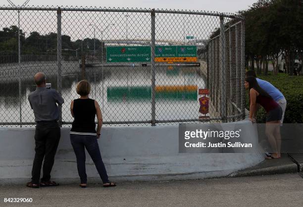 People look at a flooded section of US-90 on September 3, 2017 in Houston, Texas. A week after Hurricane Harvey hit Southern Texas, residents are...