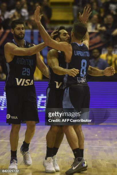 Argentina's point guard Facundo Campazzo celebrates with teammtes small forward Patricio Garino and point guard Nicolas Laprovittola after scoring...