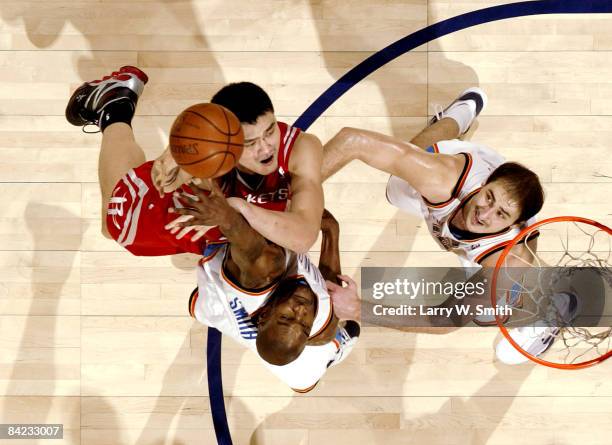 Yao Ming of the Houston Rockets shoots over Joe Smith and Nenad Krstic of the Oklahoma City Thunder at the Ford Center on January 9, 2009 in Oklahoma...