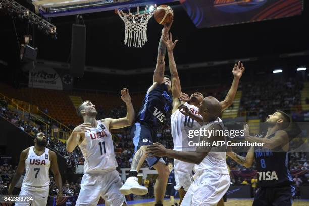 Argentina's center Gabriel Deck shoots marked by USA's center Marshall Plumpee and shooting guard Reggie Hearn during their 2017 FIBA Americas...