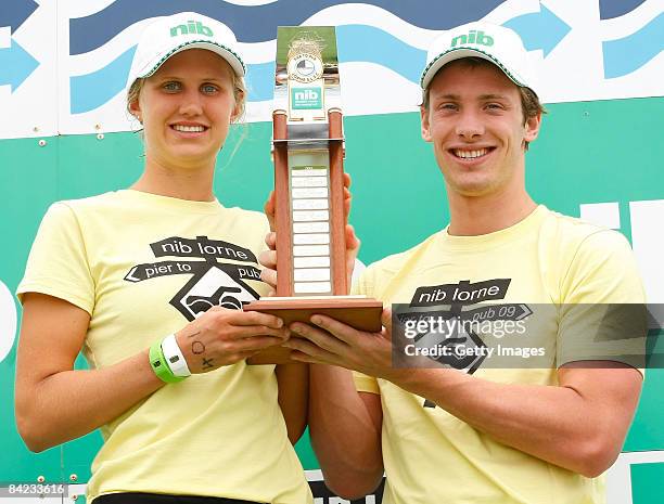 Harriet Brown and Nick Cordner pose with the trophy after winning the Male and Female Open category during the Lorne Pier To Pub open water swim at...