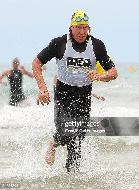 Cameron Ling of the Geelong Football Club runs out of the water during the Lorne Pier To Pub open water swim at Louttit Bay on January 10, 2009 in...