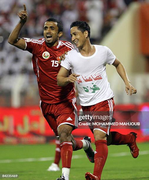 Omani player Ismaeel al-Ajmi and Bader al-Maymani, wearing a tee-shirt reading 'in solidarity with Gaza', celebrate after scoring a goal against...