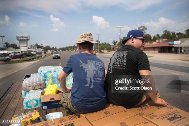 Volunteers with Merging Vets and Players distribute food water and pet food to flood victims after the town was inundated when torrential rains...