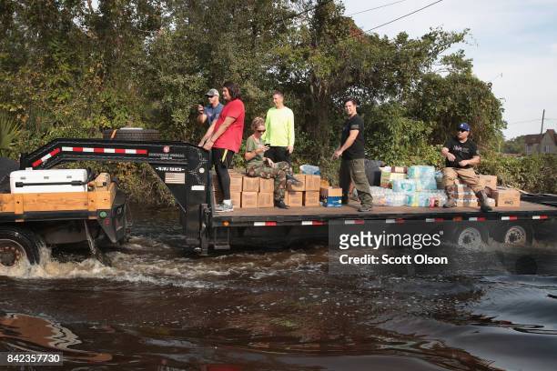 Volunteers with Merging Vets and Players distribute food water and pet food to flood victims after the town was inundated when torrential rains...