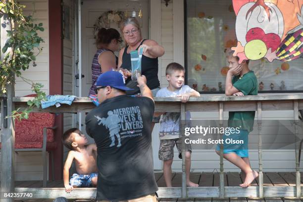 Volunteer with Merging Vets and Players distributes food, water and pet food to flood victims after the town was inundated when torrential rains...