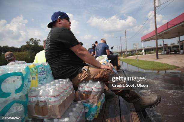 Volunteers with Merging Vets and Players distribute food water and pet food to flood victims after the town was inundated when torrential rains...