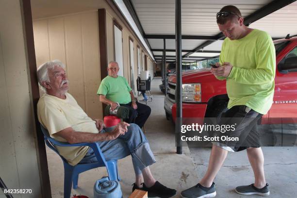 Tim Fahy , a volunteer from New Jersey, helps flood victims Ronnie Hyde , and Cecil Gossett whose apartments were heavily damaged when torrential...