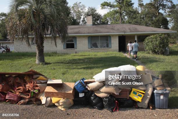 Flood victims clean up damage in their home after the town was inundated when torrential rains pounded Southeast Texas following Hurricane and...