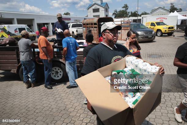 Volunteers unload a trailer full of relief supplies donated from residents of Fort Worth, Texas after torrential rains pounded Southeast Texas...
