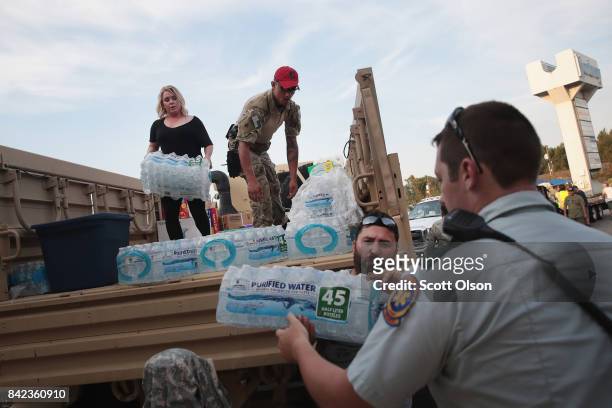 Volunteers unload a truck full of relief supplies after torrential rains pounded Southeast Texas following Hurricane and Tropical Storm Harvey...