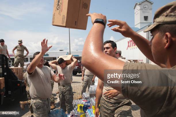 Members of the Texas Army National Guard from El Paso, Texas distribute food and water to flood victims after the town was inundated when torrential...