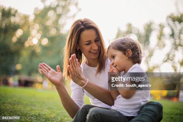 family sitting in park - nanny stock pictures, royalty-free photos & images