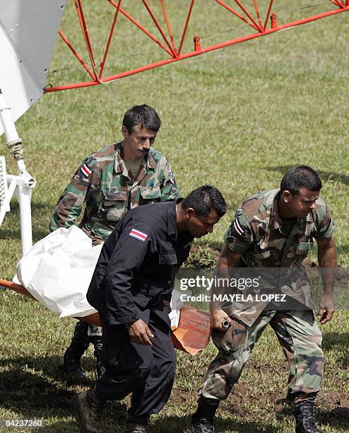 Police officers unload a corpse from a helicopter landed on a football field on January 10 at the town of San Miguel de Sarapiqui, 55 kilometers...