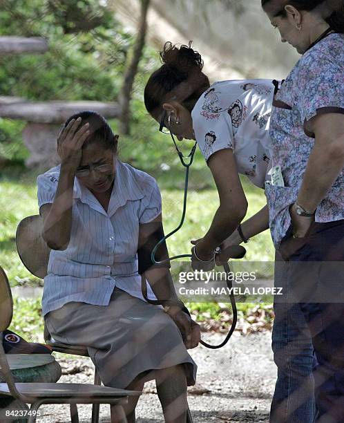 The mother of a missing child receives first aid on January 10 in San Miguel de Sarapiqui, 55 kilometers north of San Jose, where rescue units have...