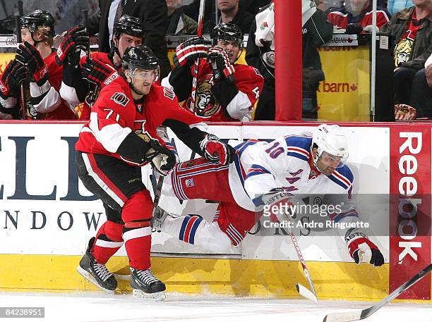Nick Foligno of the Ottawa Senators bodychecks Nigel Dawes of the New York Rangers into the boards at Scotiabank Place on January 10, 2009 in Ottawa,...