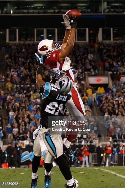 Wide receiver Larry Fitzgerald of the Arizona Cardinals catches a pass against the Ken Lucas and Charles Godfrey of the Carolina Panthers during the...