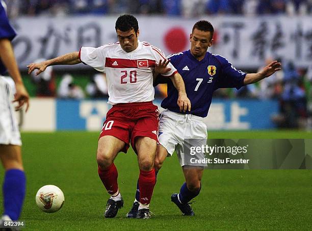 Hidetoshi Nakata of Japan tries to tackle Hakan Unsal of Turkey during the FIFA World Cup Finals 2002 Second Round match played at the Miyagi...