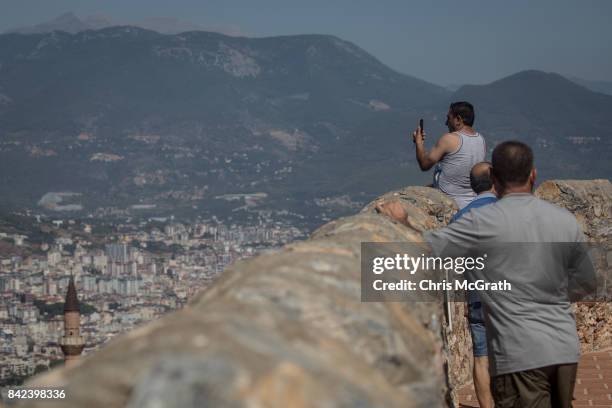 Tourists look out over Alanya from the Alanya castle on September 3, 2017 in Alanya, Turkey. Turkey's tourism industry spiraled into crisis in 2016...