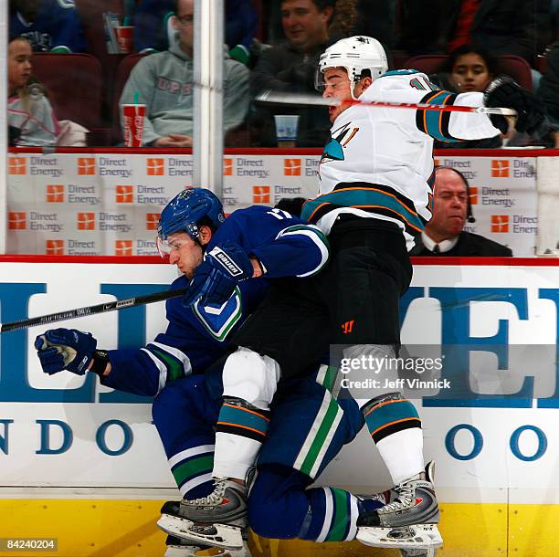 Devin Setoguchi of the San Jose Sharks hits Ryan Kesler of the Vancouver Canucks into the boards during their game at General Motors Place on January...