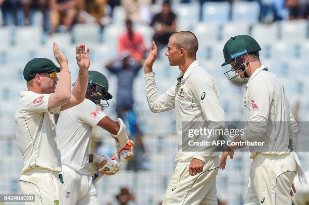 Australian cricketer Ashton Agar celebrates after the dismissal of the Bangladeshi cricketer Shakib Al Hasan during the first day of the second...