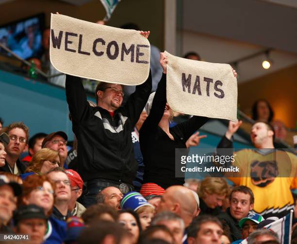 Vancouver Canuck fans hold up welcome mats as they cheer for Mats Sundin of the Vancouver Canucks during the game against the San Jose Sharks at...
