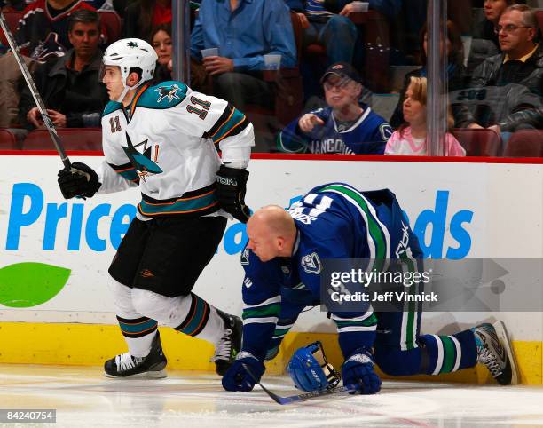 Mats Sundin of the Vancouver Canucks loses his helmet after taking a penalty on Marcel Goc of the San Jose Sharks during their game at General Motors...