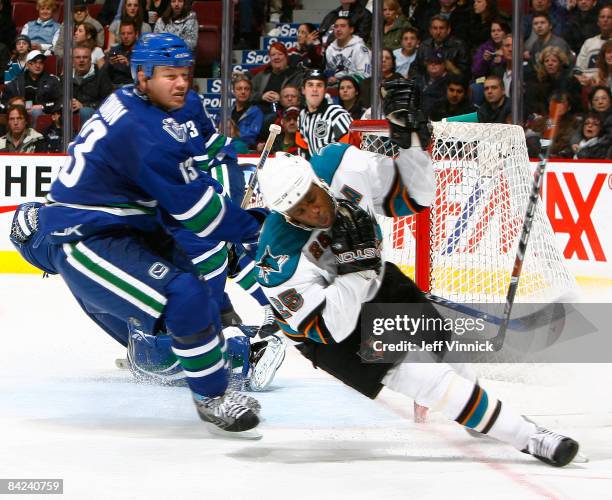 Mats Sundin of the Vancouver Canucks high sticks Mike Grier of the San Jose Sharks for a penalty during their game at General Motors Place on January...