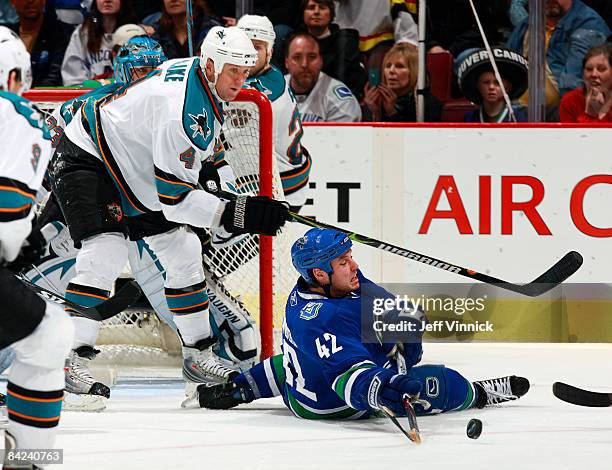Kyle Wellwood of the Vancouver Canucks is checked to the ice by Rob Blake of the San Jose Sharks during their game at General Motors Place on January...