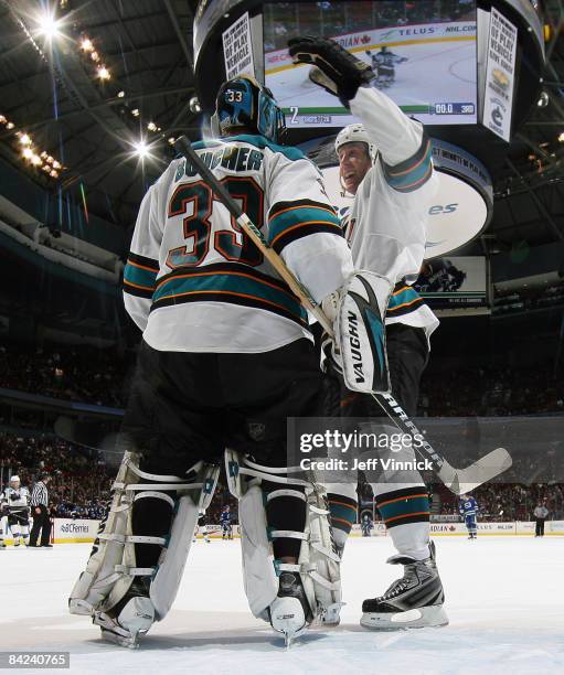 Brian Boucher of the San Jose Sharks is congratulated by teammate Joe Thornton after their win over the Vancouver Canucks at General Motors Place on...