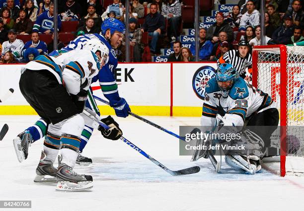 Brian Boucher of the San Jose Sharks makes a save off the shot of Mats Sundin of the Vancouver Canucks as Marc-Edouard Vlasic of the San Jose Sharks...