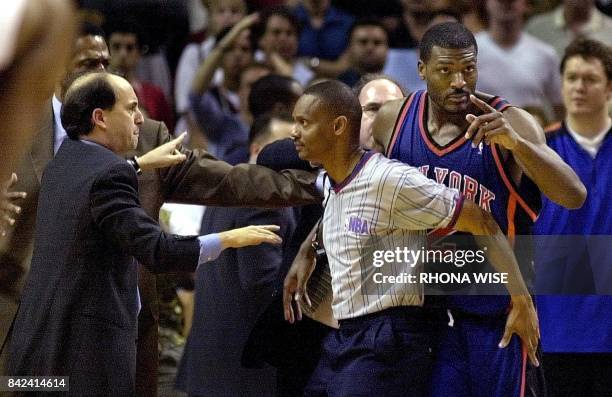 New York Knicks' forward Larry Johnson is held back by referee Michael Smith as Knicks' Head Coach Jeff VanGundy argues after Johnson had a small...