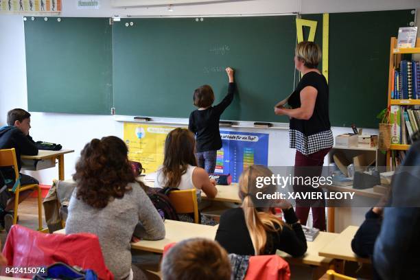 Pupils attend class on the first day of school at the La Courbe primary school in Aytre, western France, on September 4, 2017.