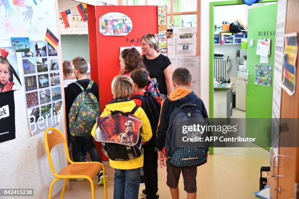 Pupils enter a classroom on the first day of school at the La Courbe primary school in Aytre, western France, on September 4, 2017. / AFP PHOTO /...