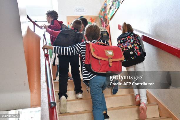 Pupils walk up stairs to a classroom on the first day of school at the La Courbe primary school in Aytre, western France, on September 4, 2017. / AFP...