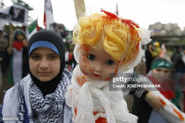 Lebanese girl holds a baby doll symbolising a Palestinian victim during a demonstration against Israel's Gaza offensive in Beirut on January 11,...